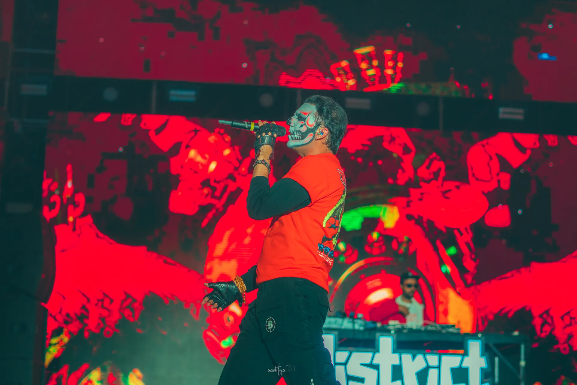 Live concert performer under red stage lights at District by Zomato festival